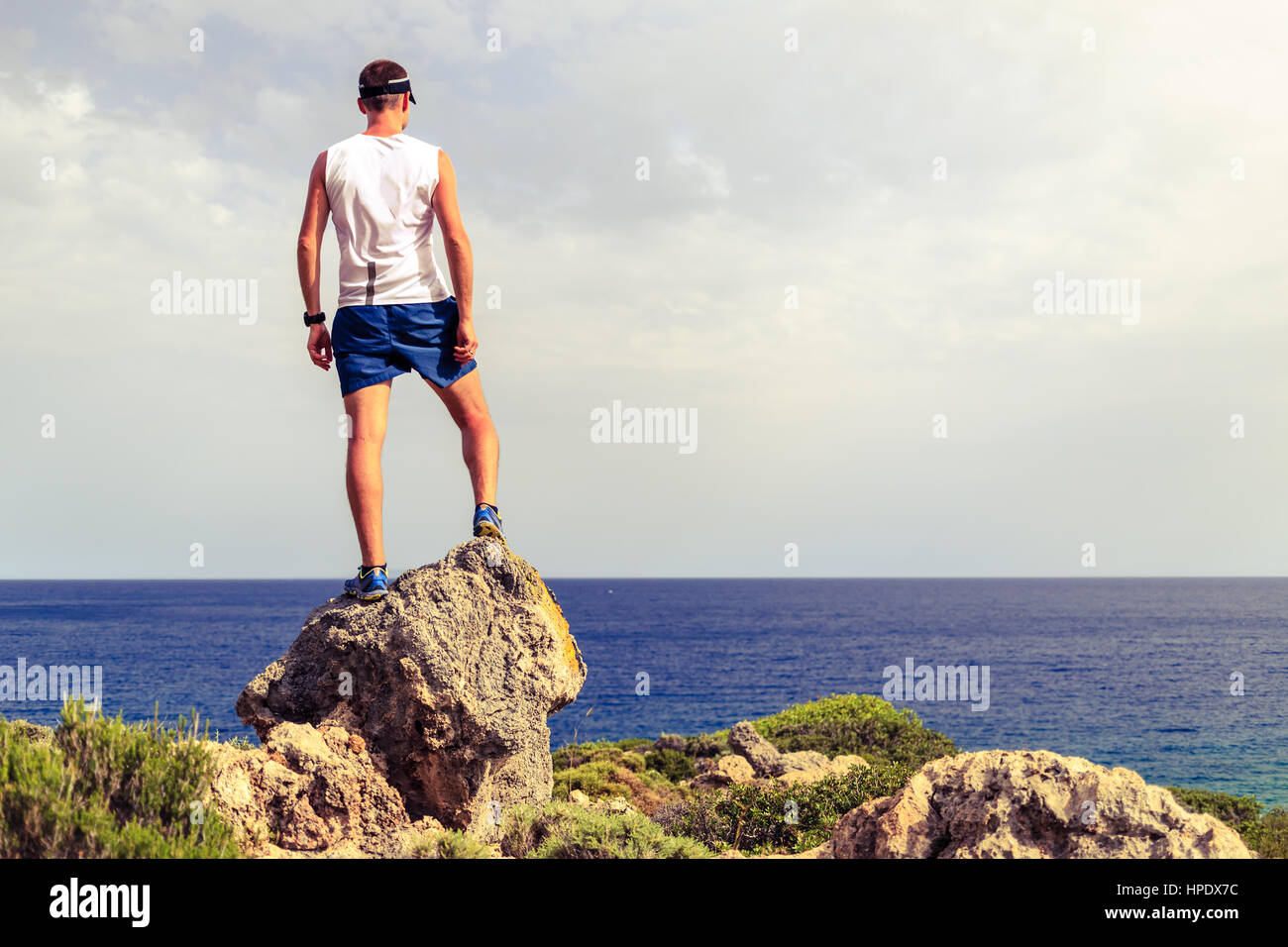Happy trail runner, conquista il successo in esecuzione o escursionismo Realizzazione concetto aziendale con l'uomo celebrando e guardando l'oceano. Foto Stock