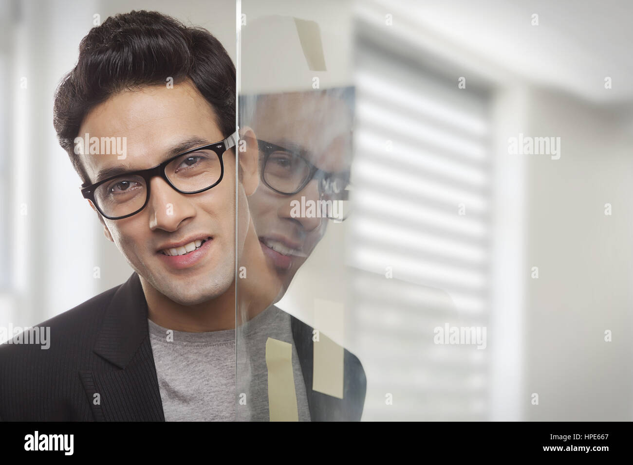 Ritratto di imprenditore in office riflessa nella finestra Foto Stock