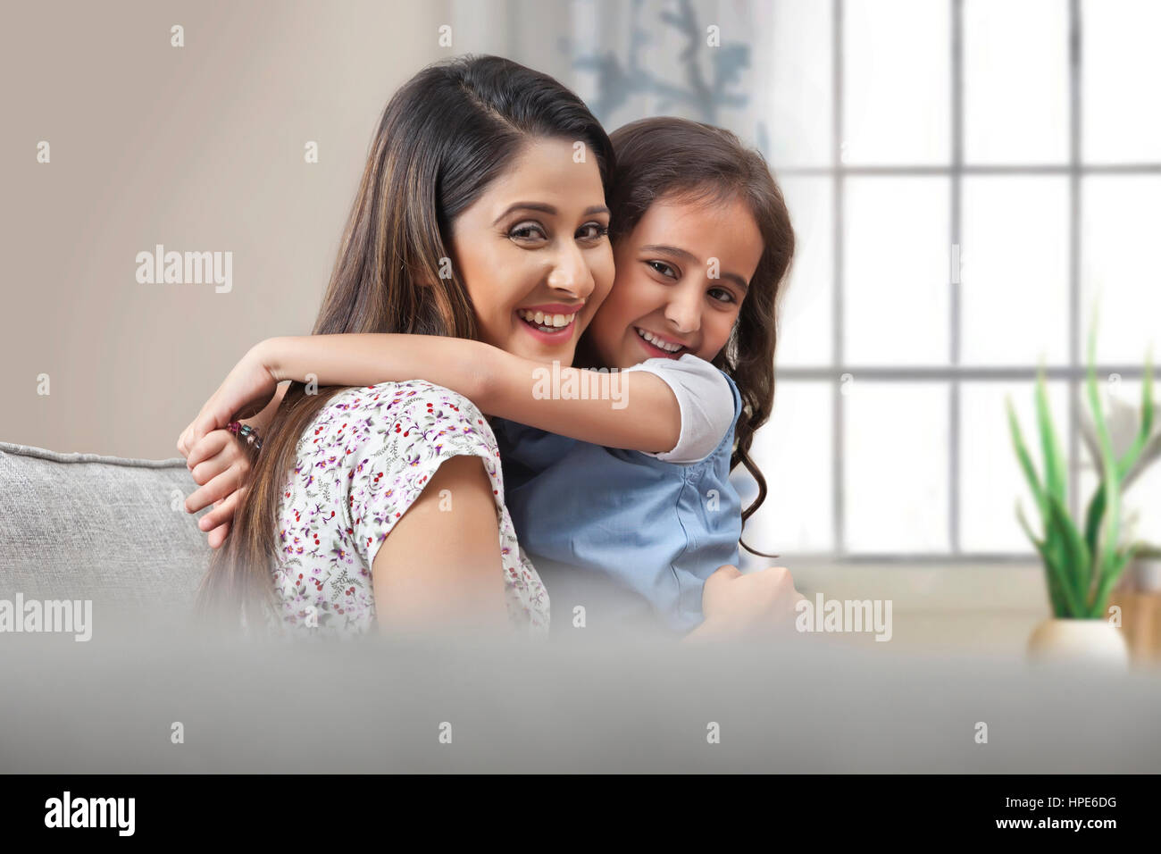 Sorridente madre e figlia avvolgente Foto Stock