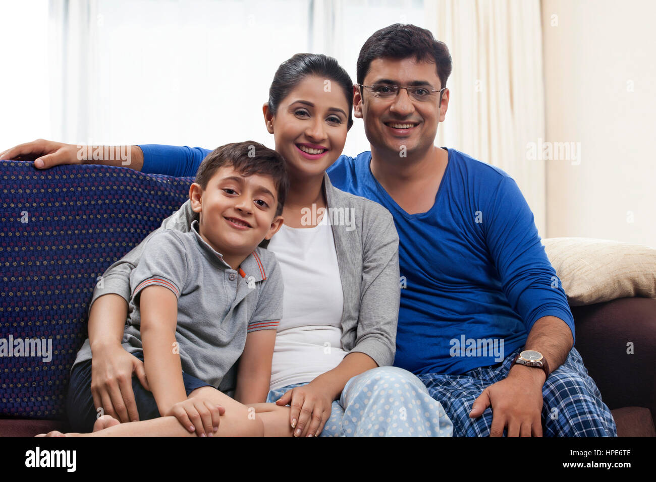 Ritratto di sorridere famiglia giovane seduto in divano Foto Stock
