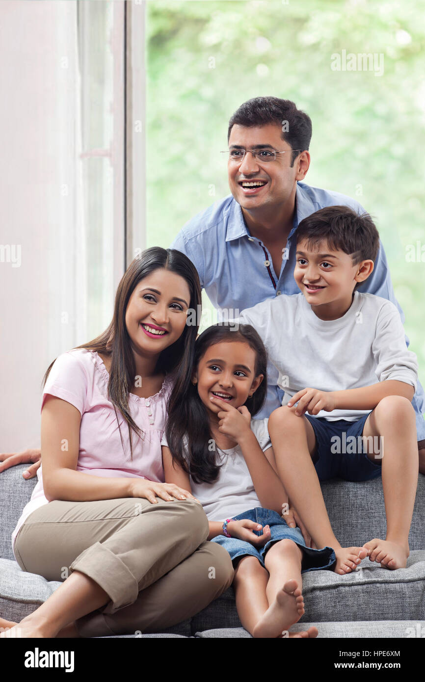 Sorridente famiglia indiana seduti sul divano insieme Foto Stock