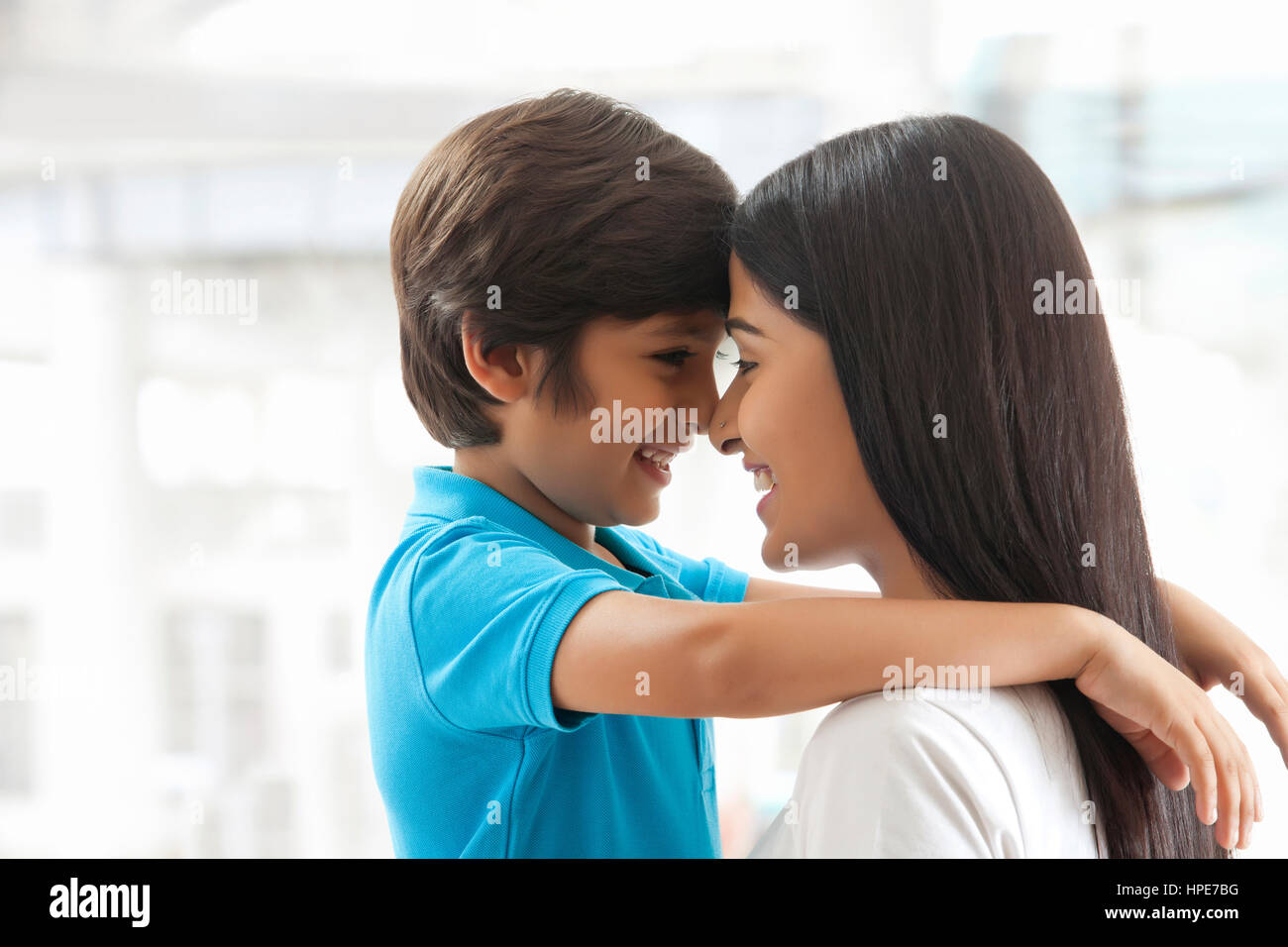 Sorridente madre e figlio di toccare fronte Foto Stock