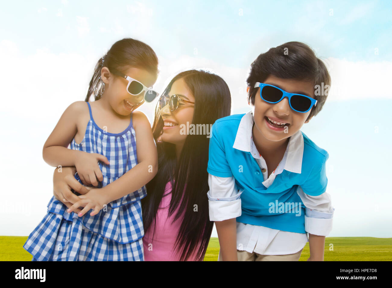 Close-up di sorridere madre e bambini indossando occhiali da sole in piedi in posizione di parcheggio Foto Stock