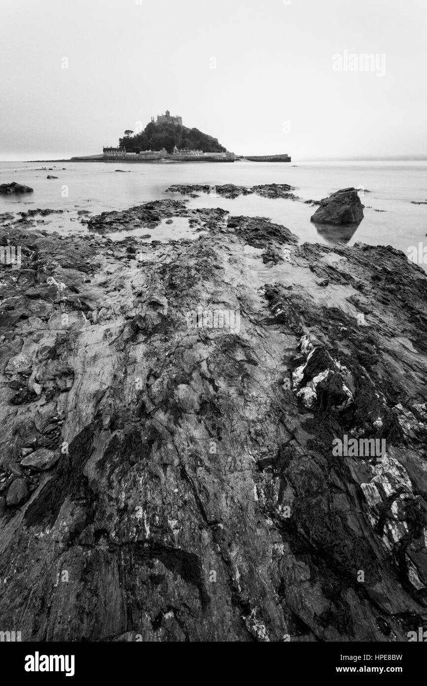 In bianco e nero alba shot su foschia mattutina con una lunga esposizione di St Michael's Mount, West Cornwall, Inghilterra, Regno Unito nel mese di febbraio Foto Stock