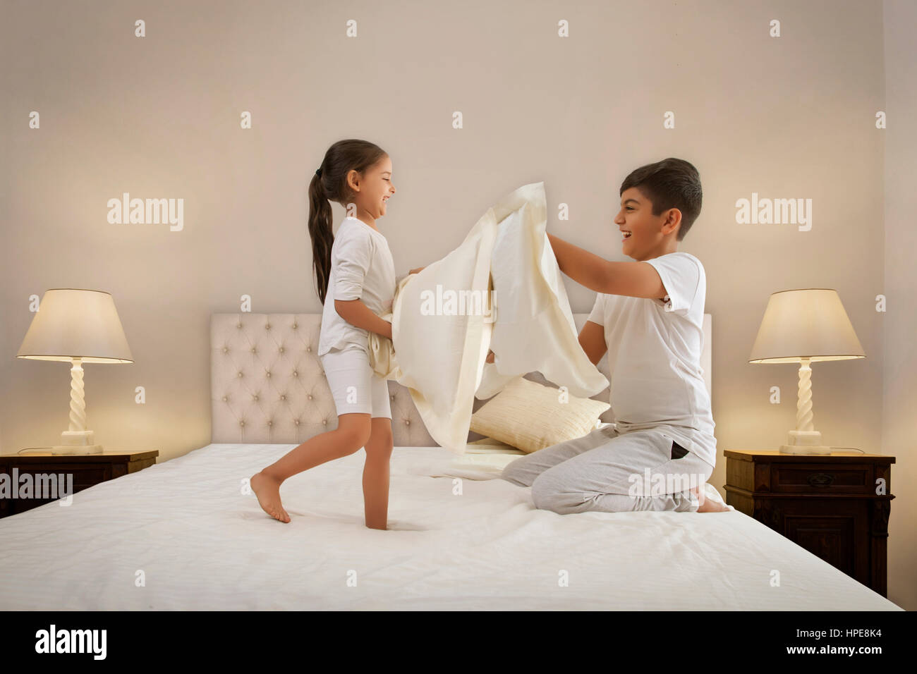 Fratello e Sorella avente un cuscino lotta nel letto Foto Stock