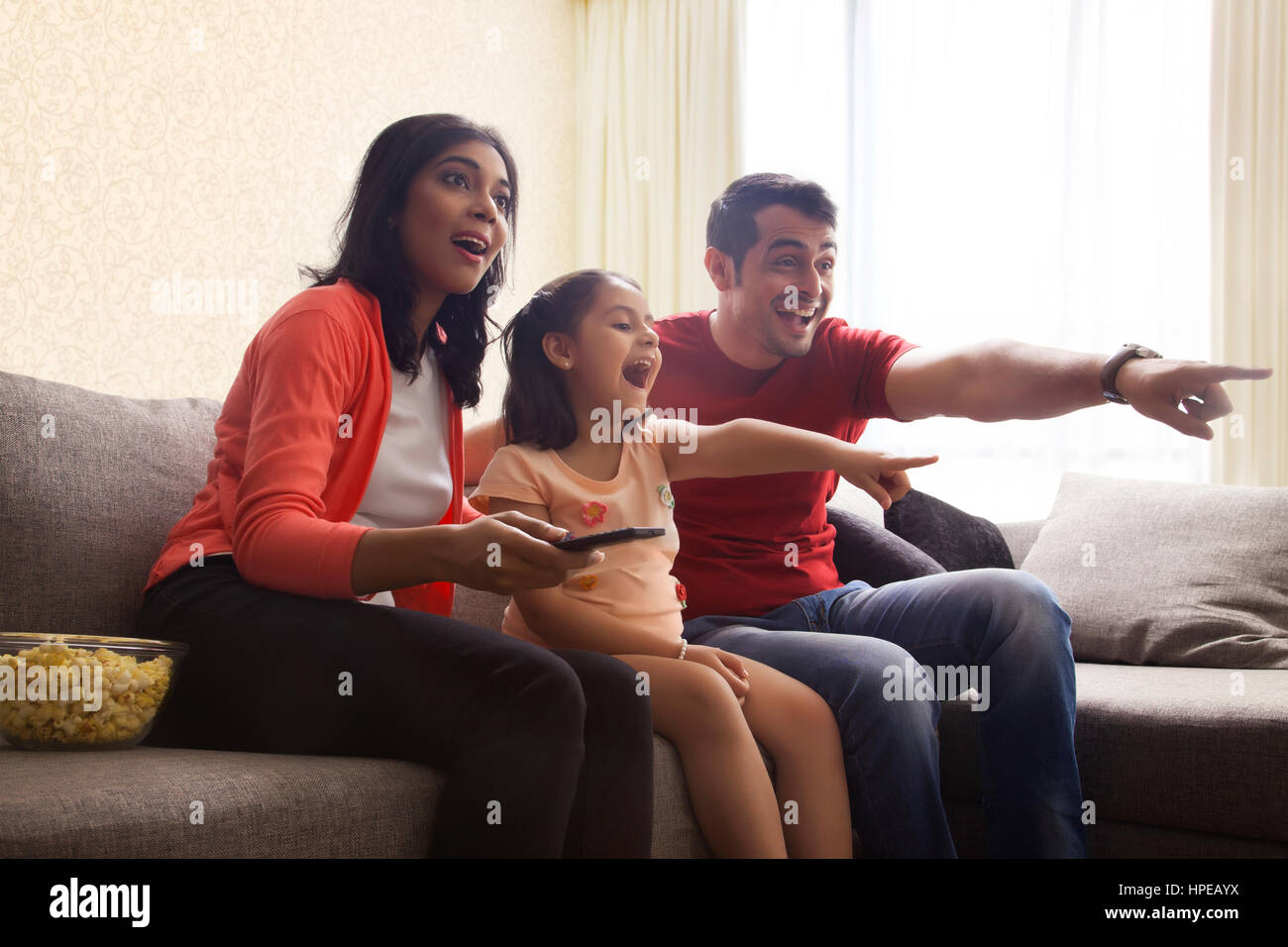 Famiglia eccitato puntando al televisore Foto Stock