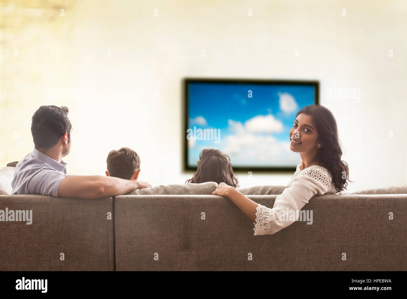 Famiglia di guardare la televisione in salotto Foto Stock