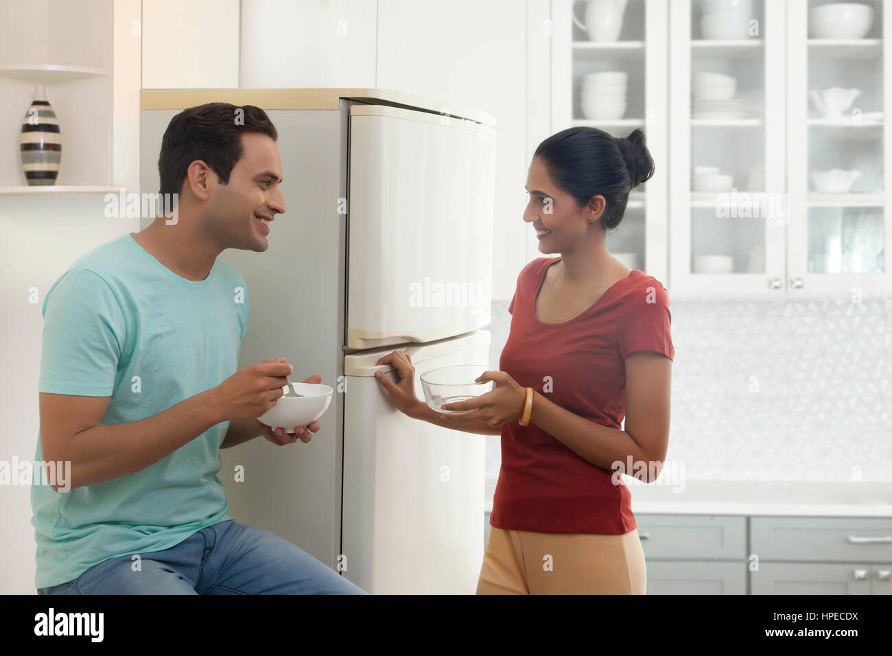 Matura in piedi in cucina a mangiare la prima colazione Foto Stock