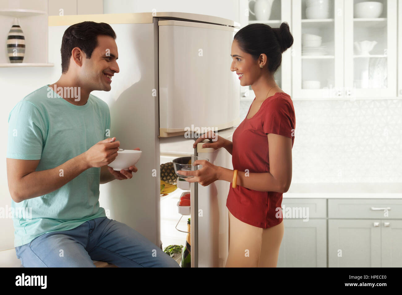 Matura in piedi in cucina a mangiare la prima colazione Foto Stock