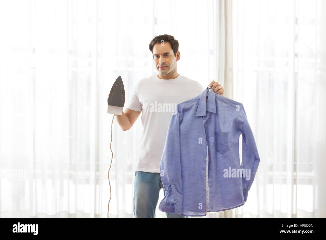 Ritratto di uomo con ferro da stiro e camicia Foto Stock