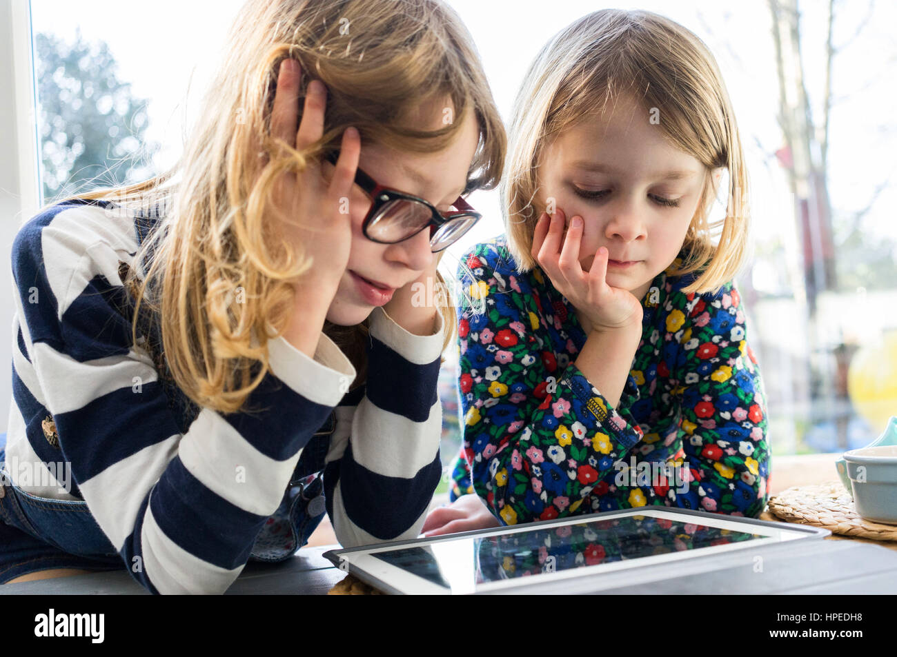 Ragazze su tablet a casa Foto Stock