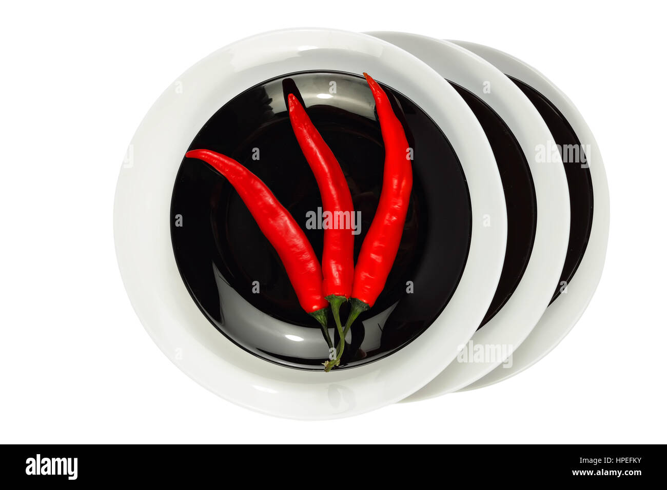 Peperoncino rosso sulla piastra nera isolati su sfondo bianco Foto Stock