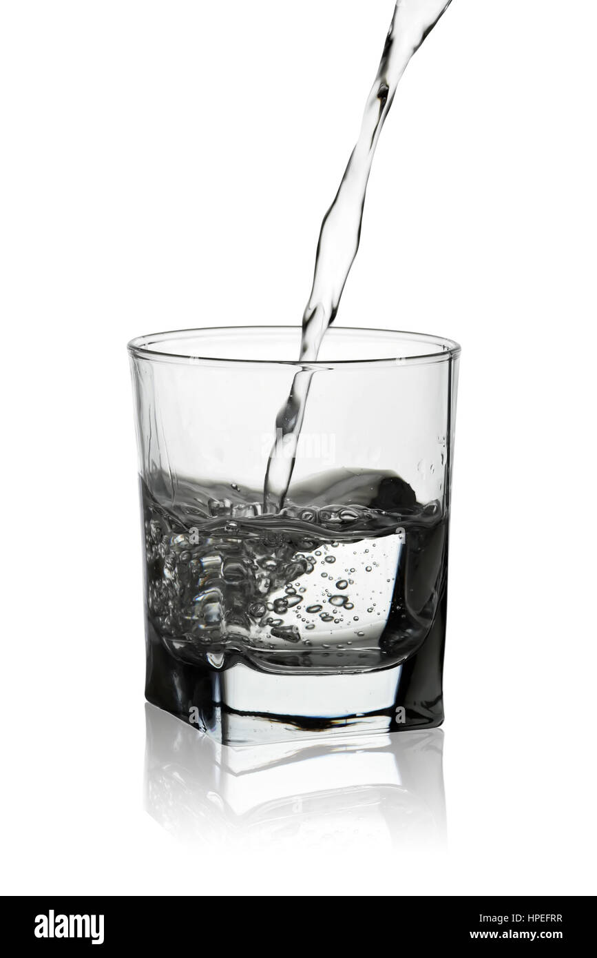 Acqua versando in vetro con la sua riflessione isolati su sfondo bianco Foto Stock