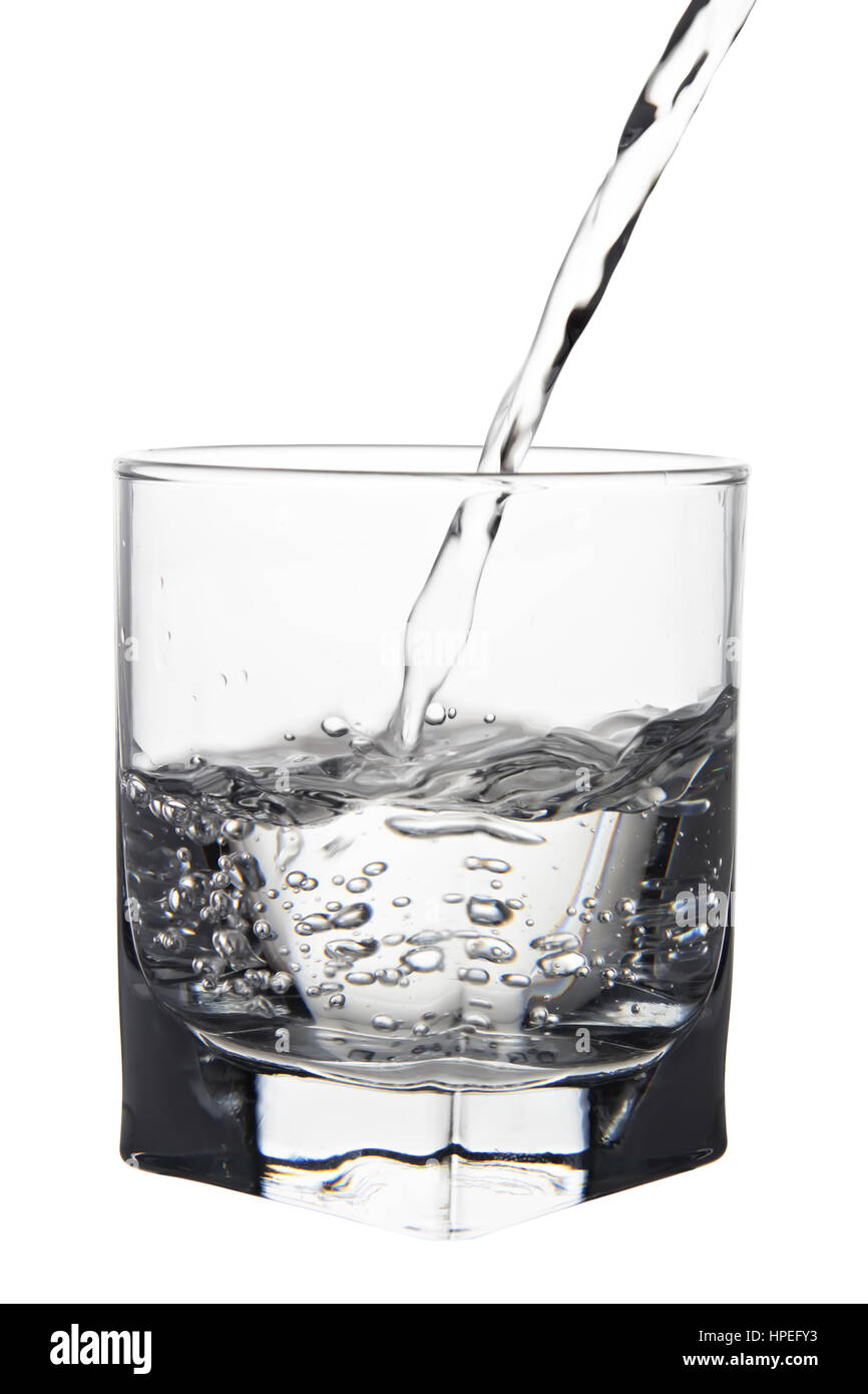 Acqua con bolle di aria versando in vetro vista closeup isolati su sfondo bianco Foto Stock