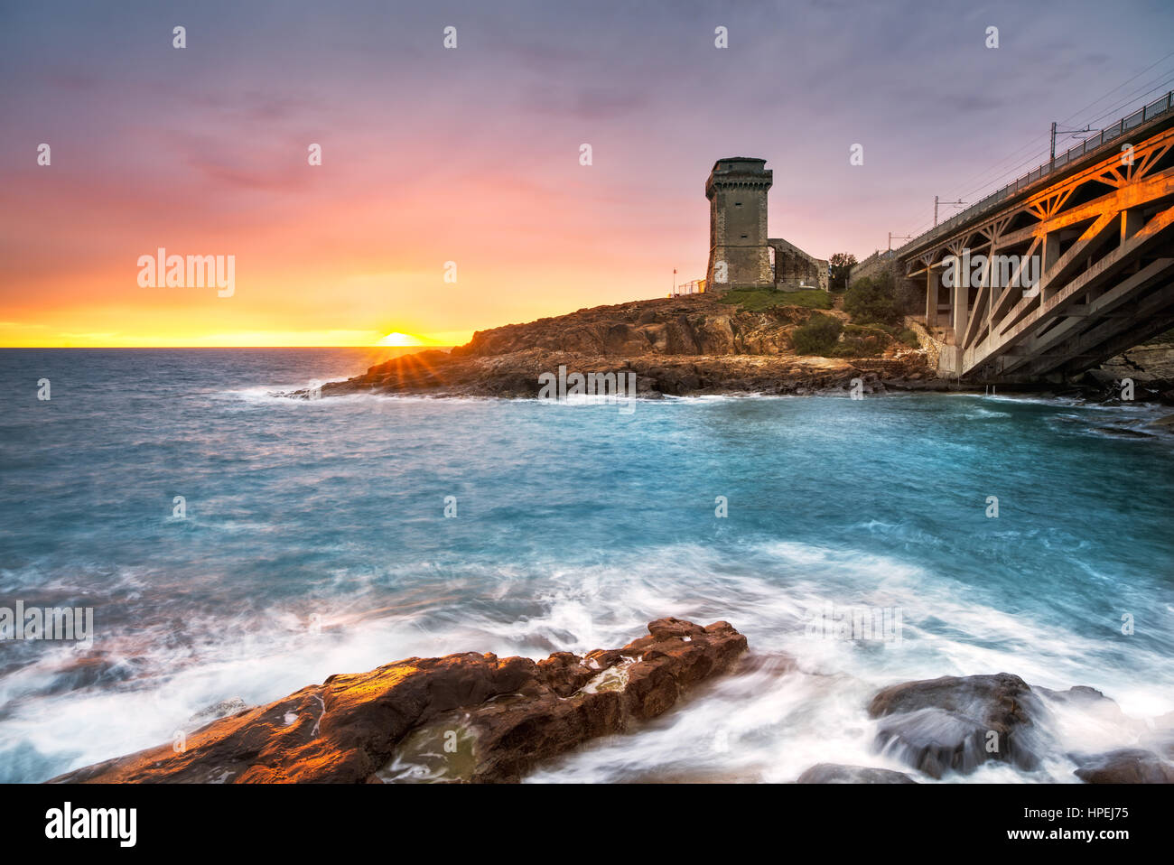 Calafuria Tower sulla scogliera rock, aurelia ponte sul mare e sul tramonto. Toscana, Italia, Europa Foto Stock