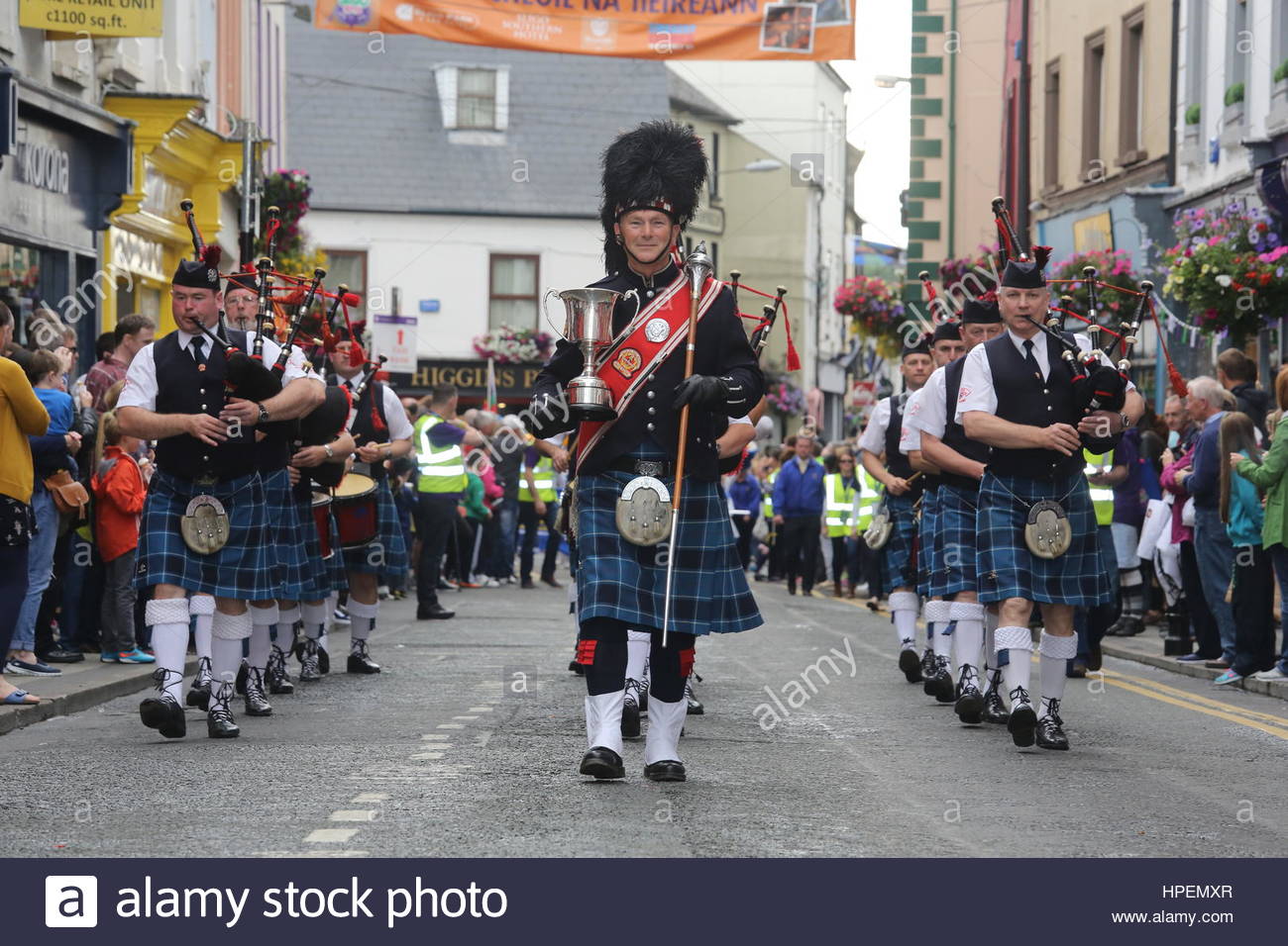 Irish pipe band marche attraverso Sligo in testa alla parata finale per contrassegnare il vicino di Fleadh Cheoil na hEireann, un festival di musica irlandese Foto Stock