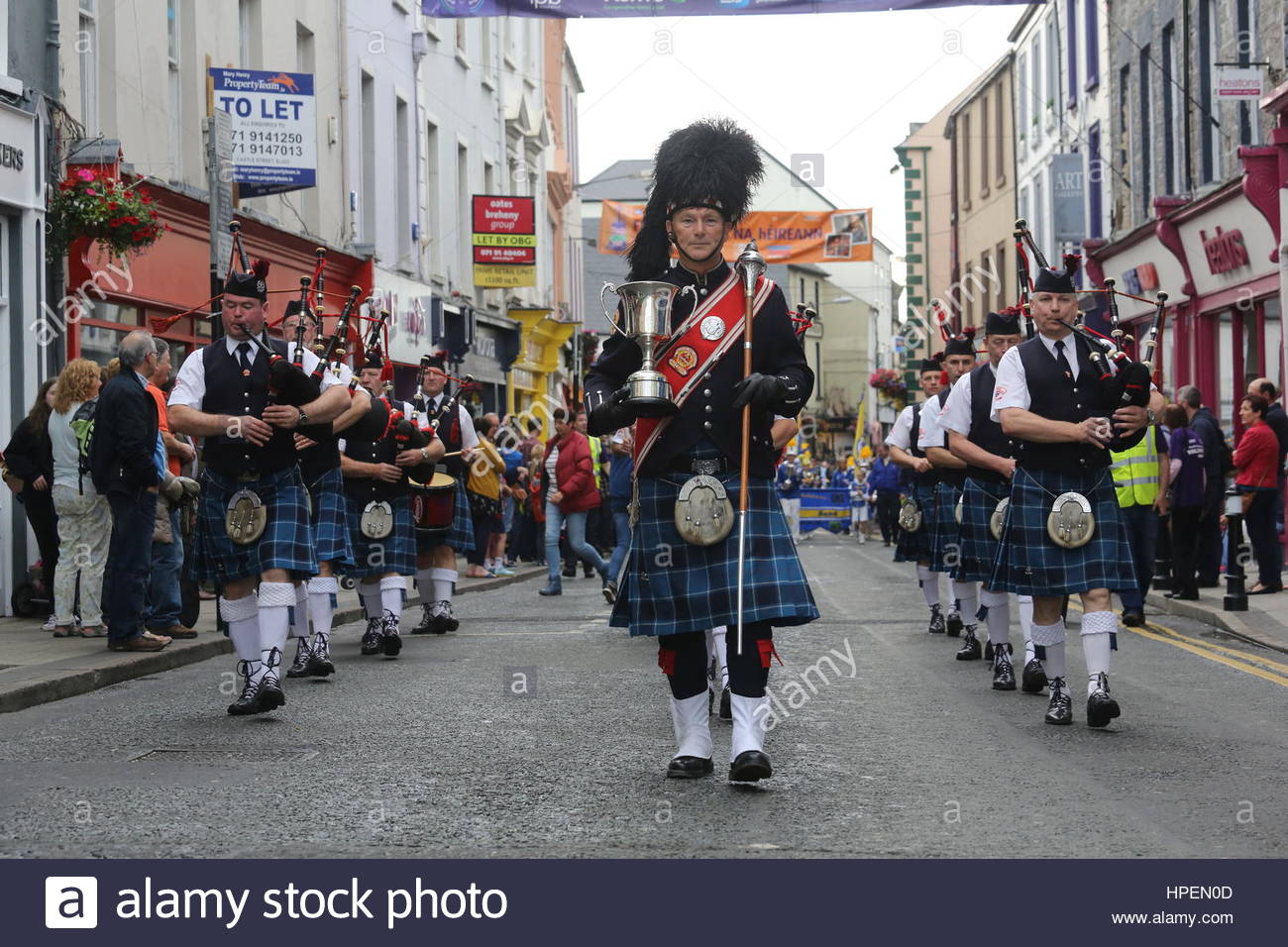 Irish pipe band marche attraverso Sligo in testa alla parata finale per contrassegnare il vicino di Fleadh Cheoil na hEireann, un festival di musica irlandese Foto Stock