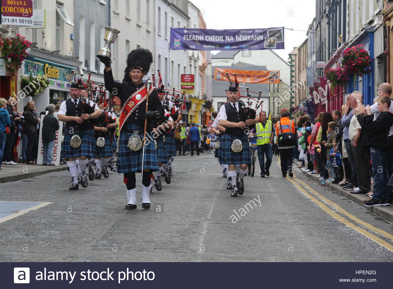 Irish pipe band marche attraverso Sligo in testa alla parata finale per contrassegnare il vicino di Fleadh Cheoil na hEireann, un festival di musica irlandese Foto Stock