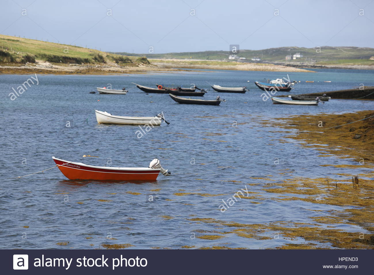 Piccole imbarcazioni si trovano in acque poco profonde lungo la costa occidentale dell'Irlanda. Foto Stock