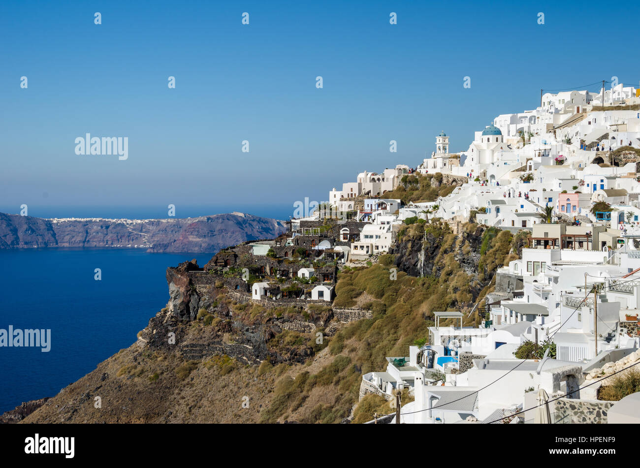 Vista di Thira, città greca sull'isola Santorini con le sue tradizionali case bianche, chiese con il loro tipico blu dipinto di cupole e il Aege Foto Stock