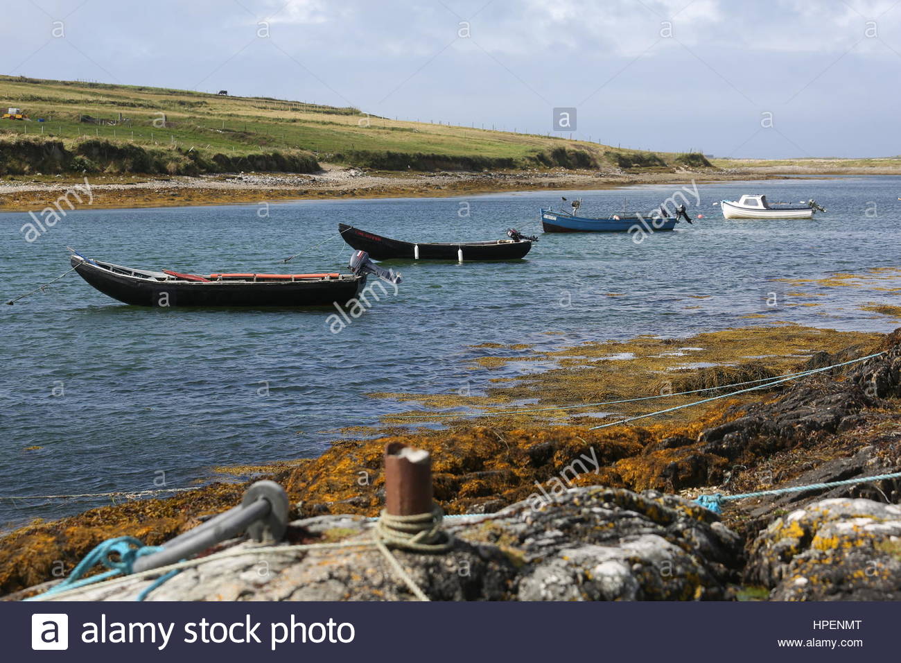 Piccole imbarcazioni si trovano in acque poco profonde lungo la costa occidentale dell'Irlanda. Foto Stock