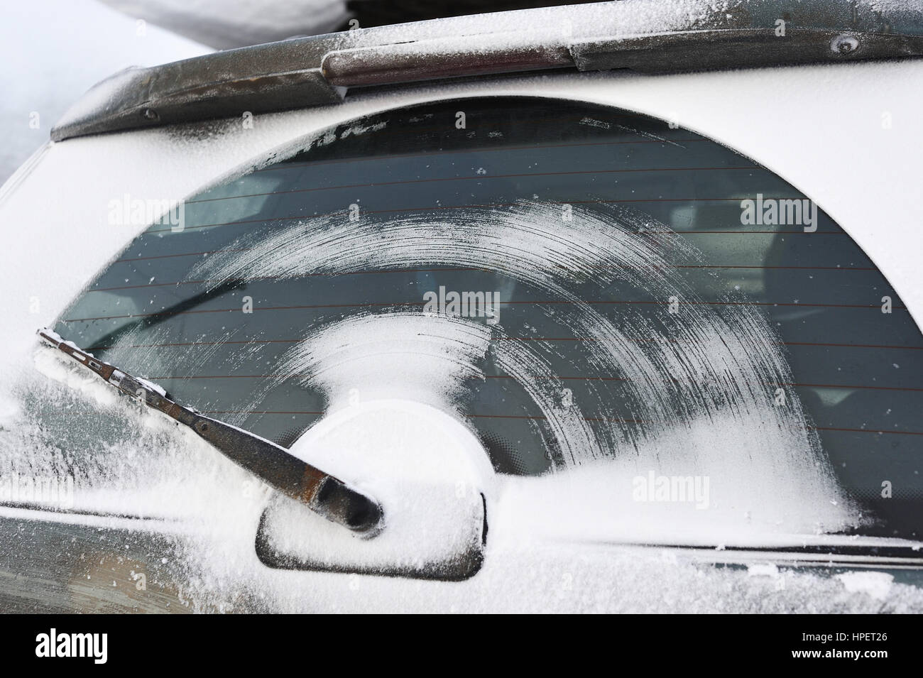 Il tergicristallo del finestrino posteriore del carro dopo la guida su una strada innevata. Foto Stock