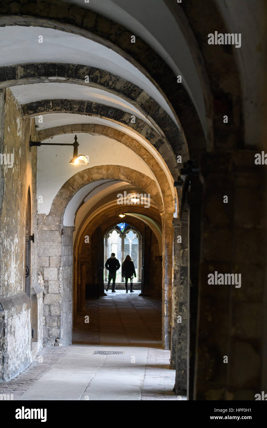 I turisti alla fine di un corridoio leding al chiostro presso la cattedrale di Canterbury, Inghilterra. Foto Stock