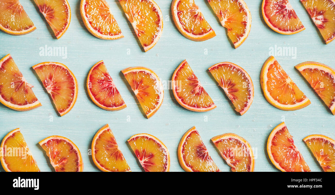 Frutto naturale concetto di pattern. Fresco sangue succose fette di arancio sulla luce colorata in blu sullo sfondo della tabella, vista dall'alto, formato wide Foto Stock