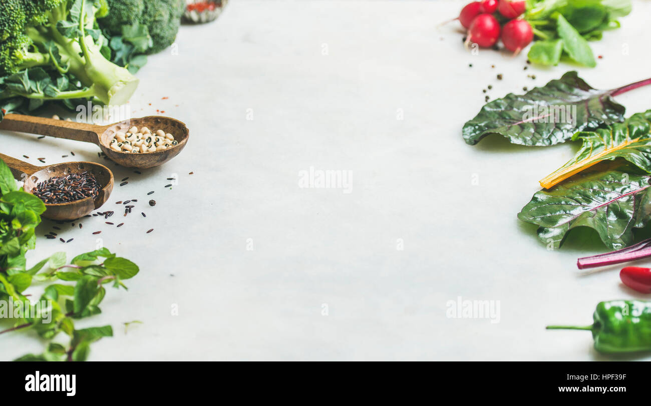 Crudo fresco verdi, verdure e cereali oltre in marmo grigio chiaro bancone cucina, copia dello spazio. Pulire mangiare, sano, Vegana Vegetariana, detox, dietin Foto Stock
