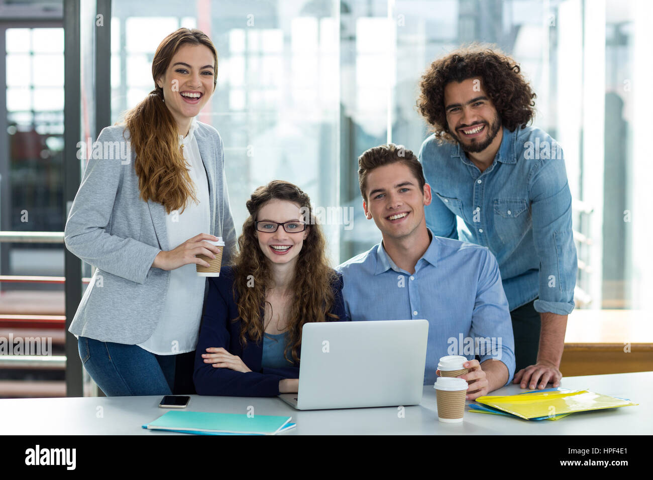 Ritratto di sorridere business team che lavora su un computer portatile in riunione in ufficio Foto Stock