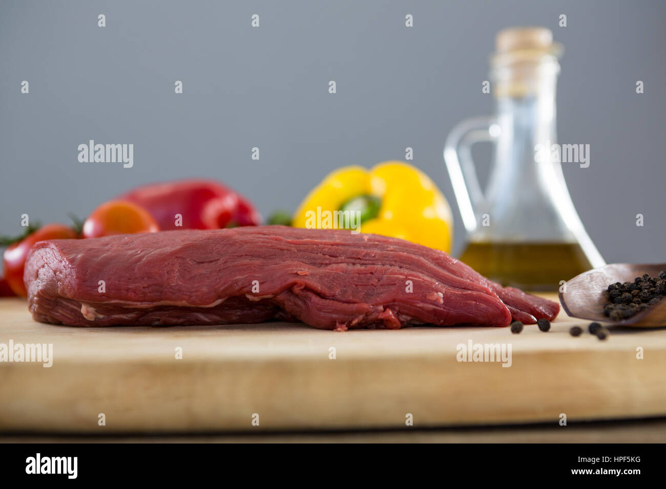 Materie bistecca e gli ingredienti sul vassoio di legno contro lo sfondo di legno Foto Stock