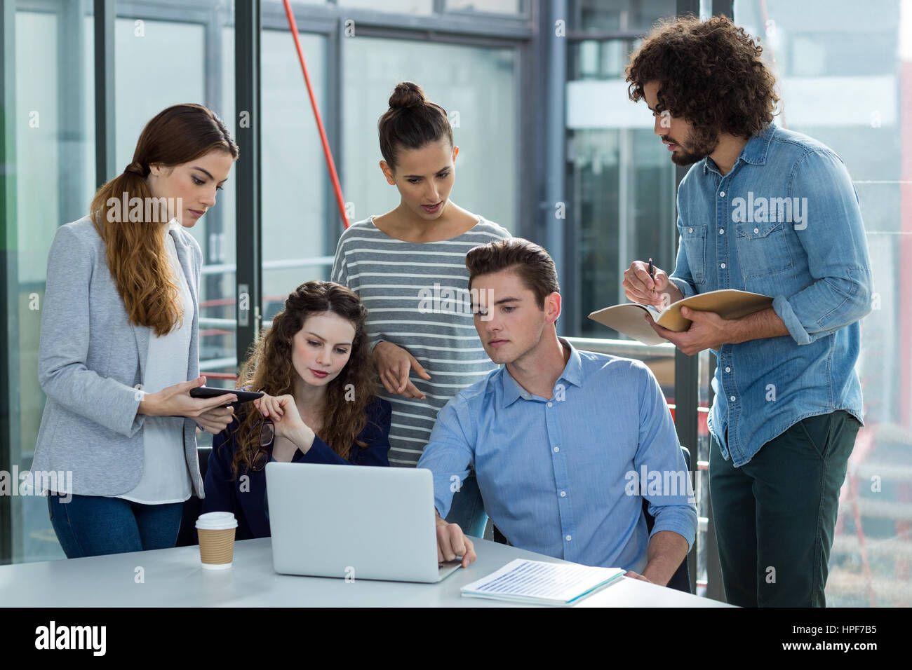 Il team Aziende a discutere su laptop in riunione in ufficio Foto Stock