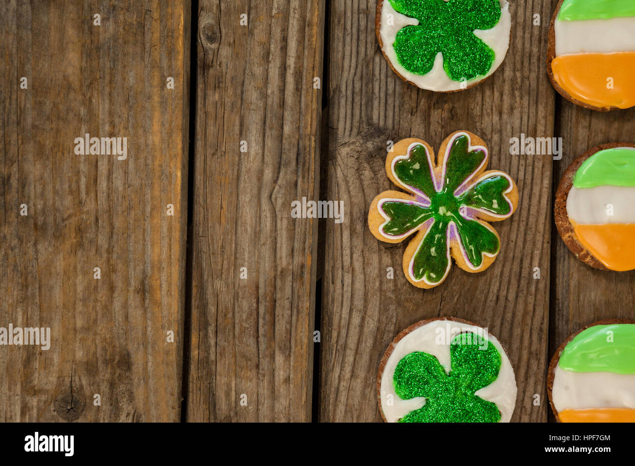 San Patrizio giorno cookie decorato con bandiera irlandese e shamrock condimenti su sfondo di legno Foto Stock