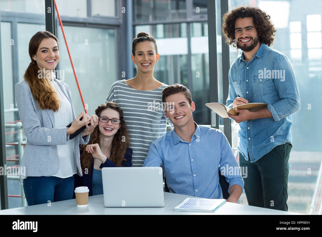 Ritratto di sorridere il team Aziende a discutere su laptop in riunione in ufficio Foto Stock