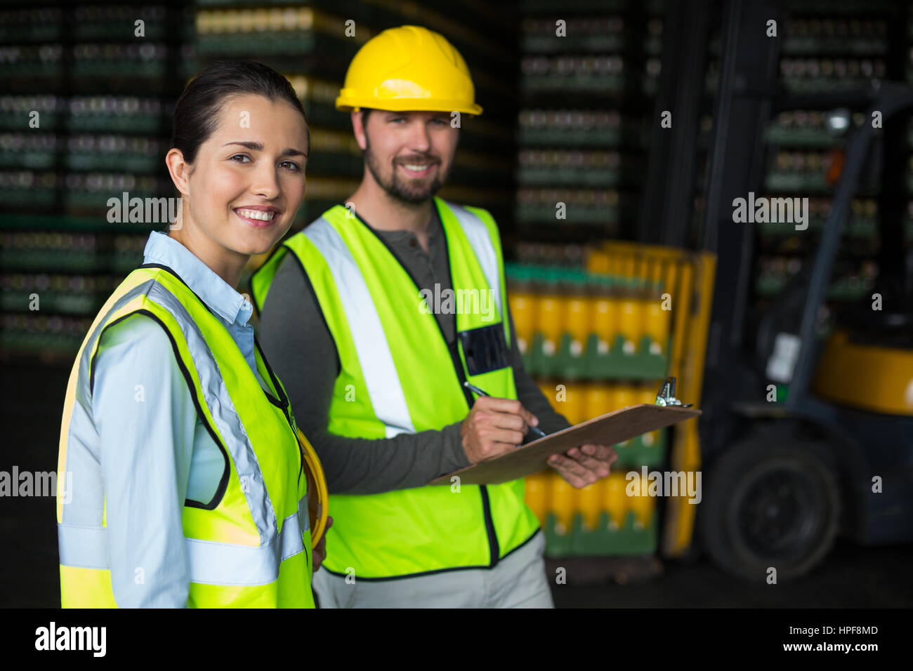 Ritratto di lavoratori in fabbrica a discutere di inventario su appunti a bevande fabbrica di produzione Foto Stock