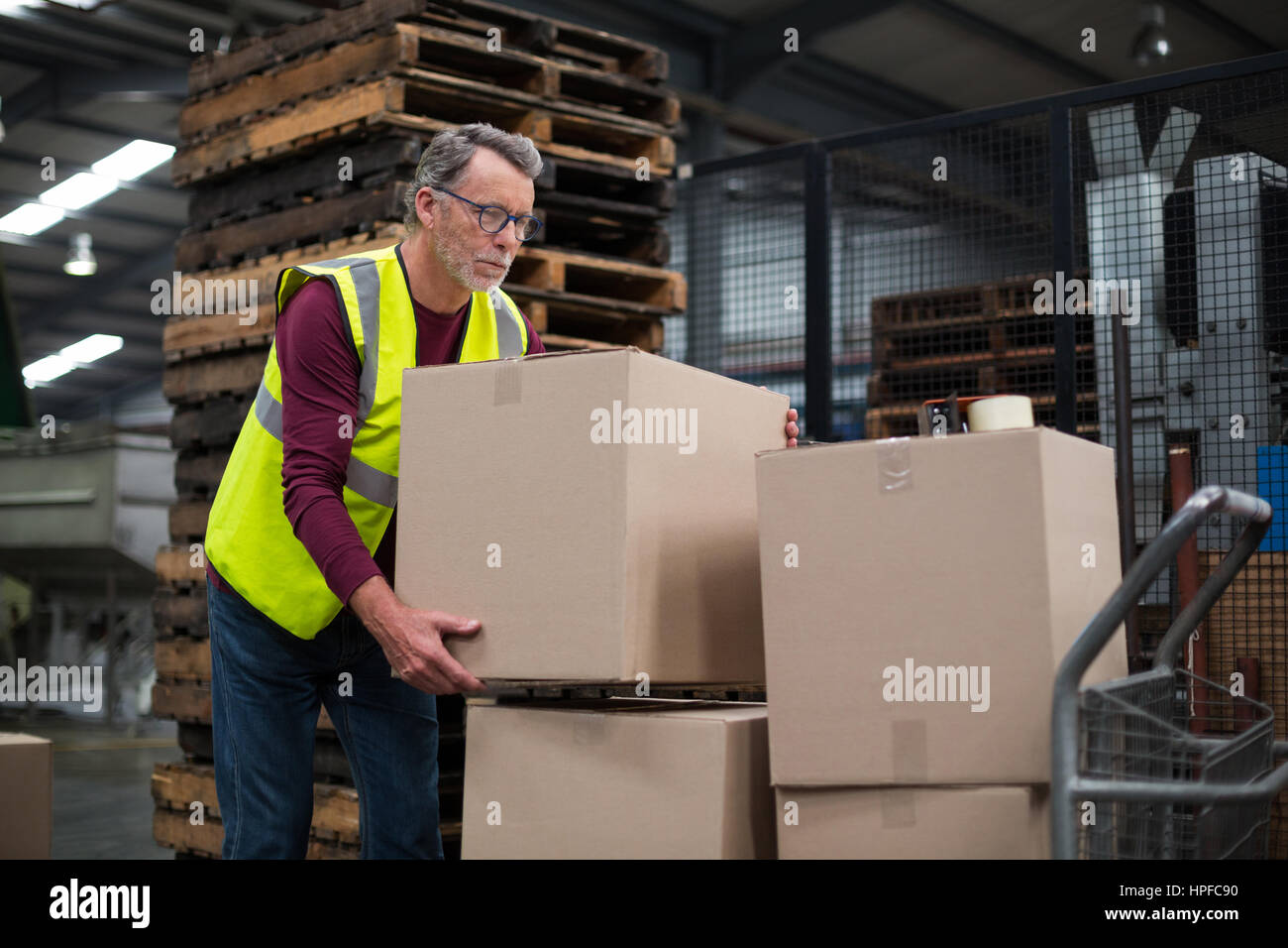 Operaio di fabbrica il caricamento di scatole di cartone sul carrello in  bevande fabbrica di produzione Foto stock - Alamy