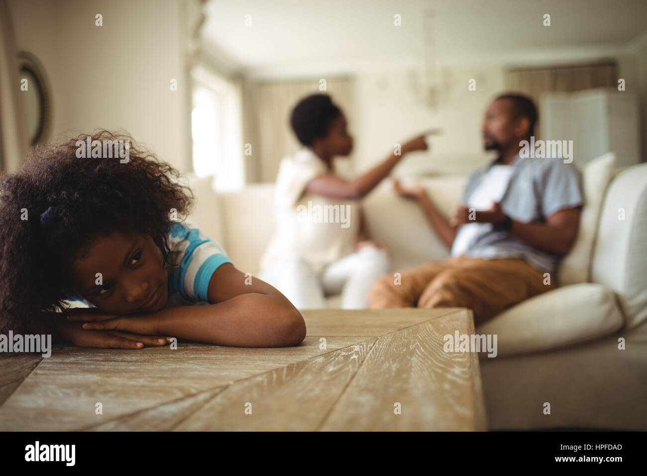 Ragazza triste ascoltando i suoi genitori discutere in casa Foto Stock