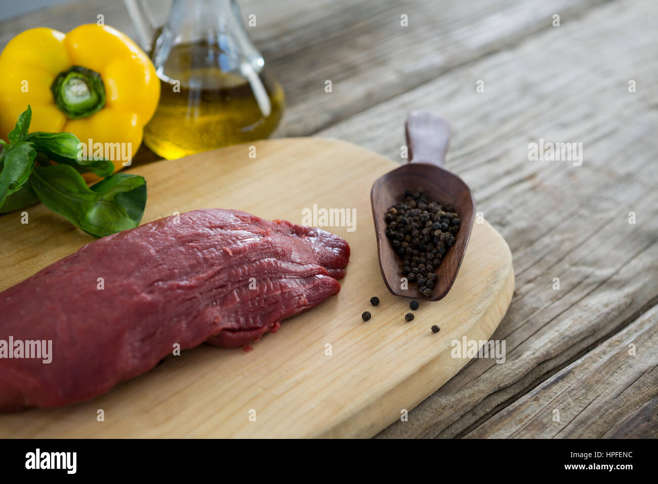 Materie bistecca e gli ingredienti sul vassoio di legno contro lo sfondo di legno Foto Stock