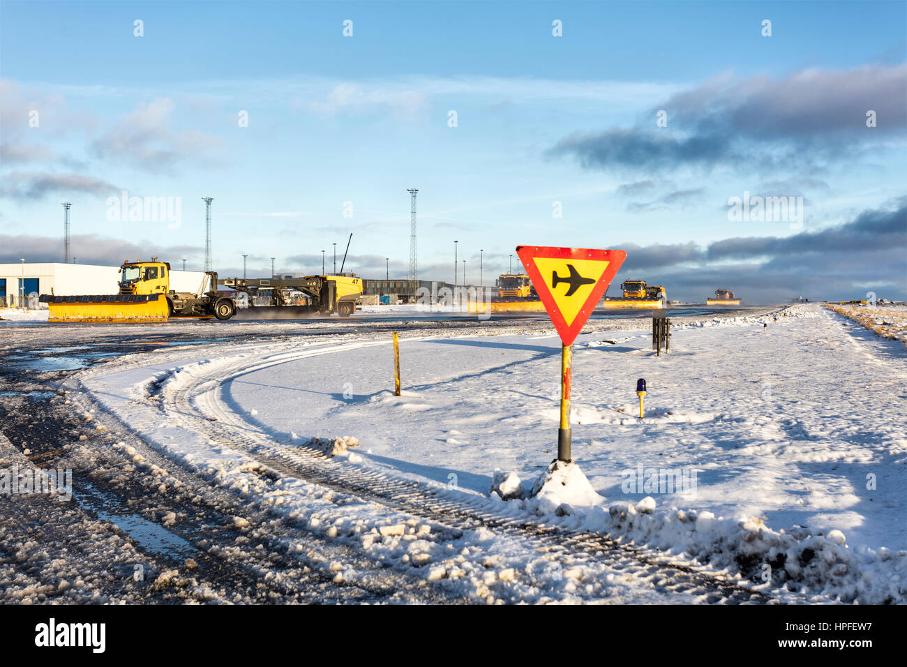 Spazzaneve guidando lungo una pista di rullaggio all'Aeroporto Internazionale di Keflavik in Islanda. Foto Stock