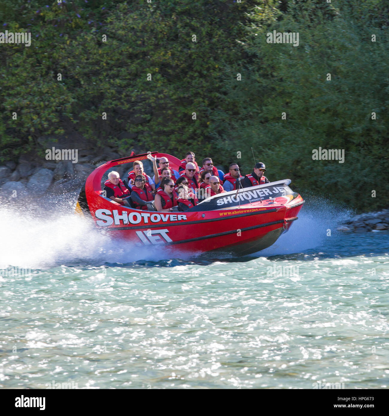 Queenstown, Otago, Nuova Zelanda. Shotover Jet Boat accelerando attraverso le acque turchesi e cristalline del fiume Shotover. Foto Stock