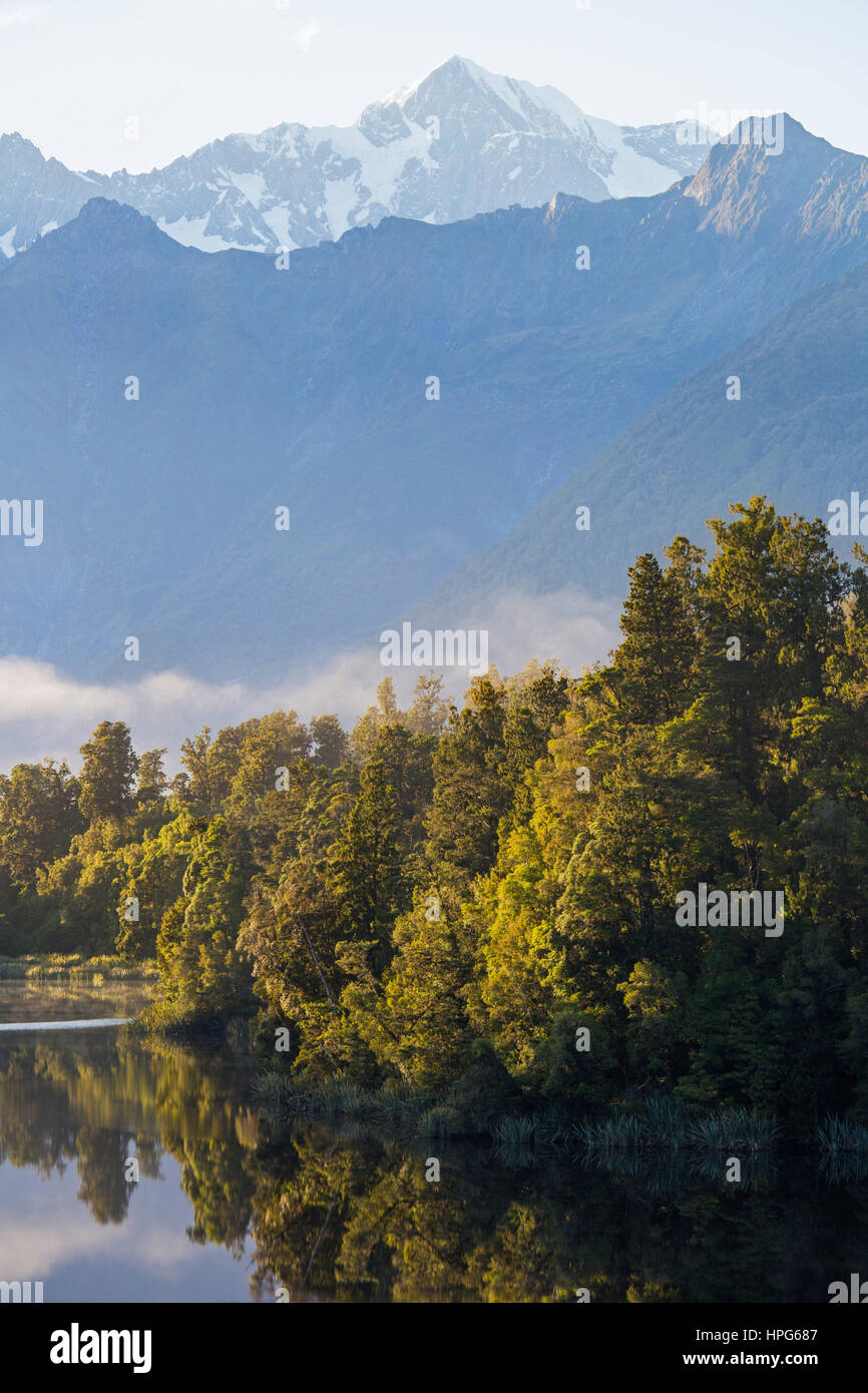 Fox Glacier, Westland Tai Poutini National Park, West Coast, Nuova Zelanda. Vista sul tranquillo Lago Matheson a Aoraki/Mount Cook, alba. Foto Stock