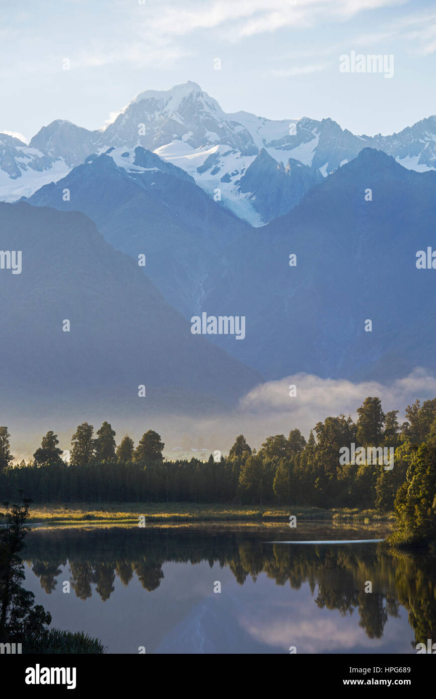 Fox Glacier, Westland Tai Poutini National Park, West Coast, Nuova Zelanda. Vista sul tranquillo Lago Matheson a Mount Tasman, alba. Foto Stock