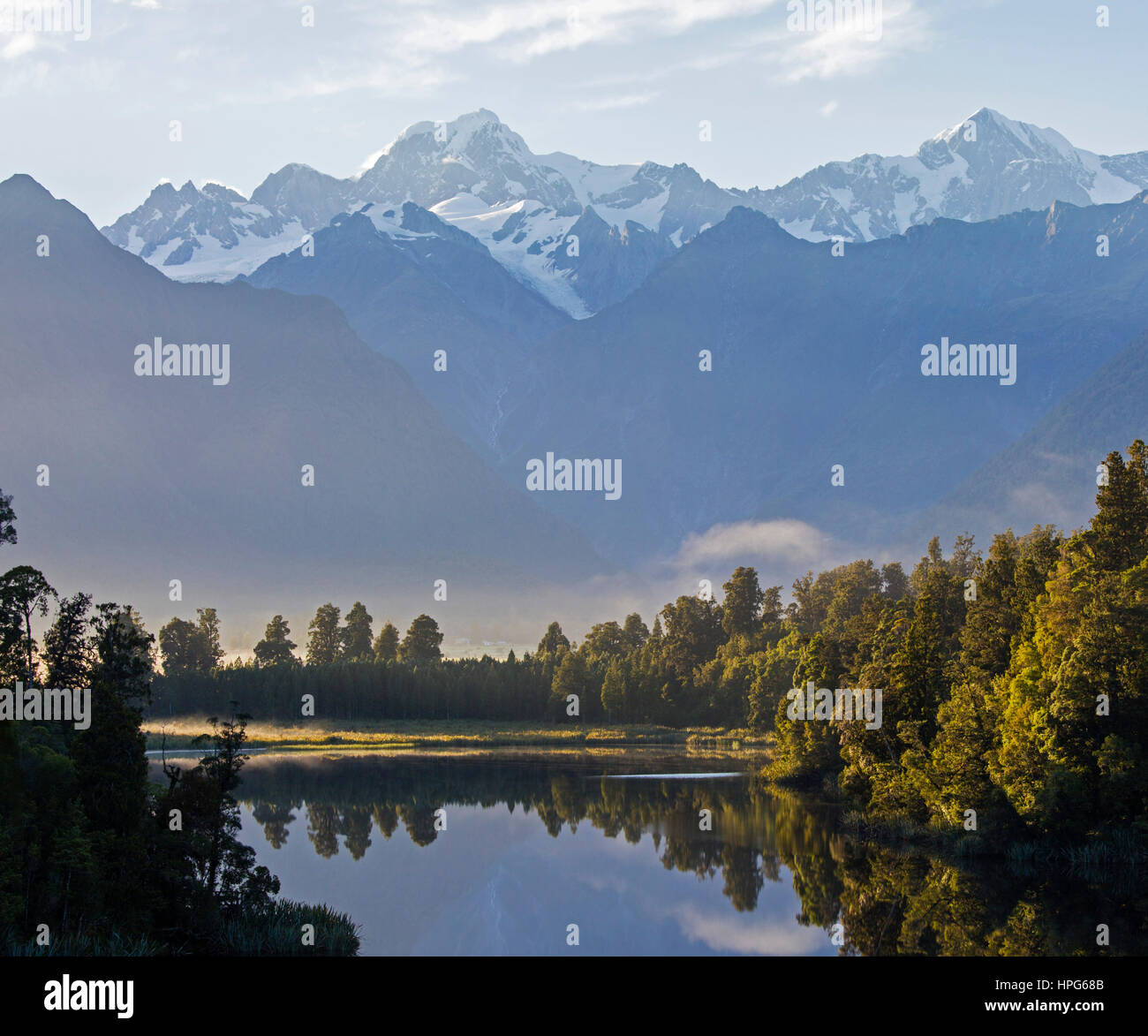 Fox Glacier, Westland Tai Poutini National Park, West Coast, Nuova Zelanda. Panorama del Lago Matheson a Mount Tasman e Aoraki/Mount Cook, alba. Foto Stock