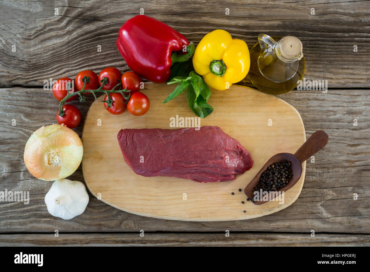 Materie bistecca e gli ingredienti sul vassoio di legno contro lo sfondo di legno Foto Stock