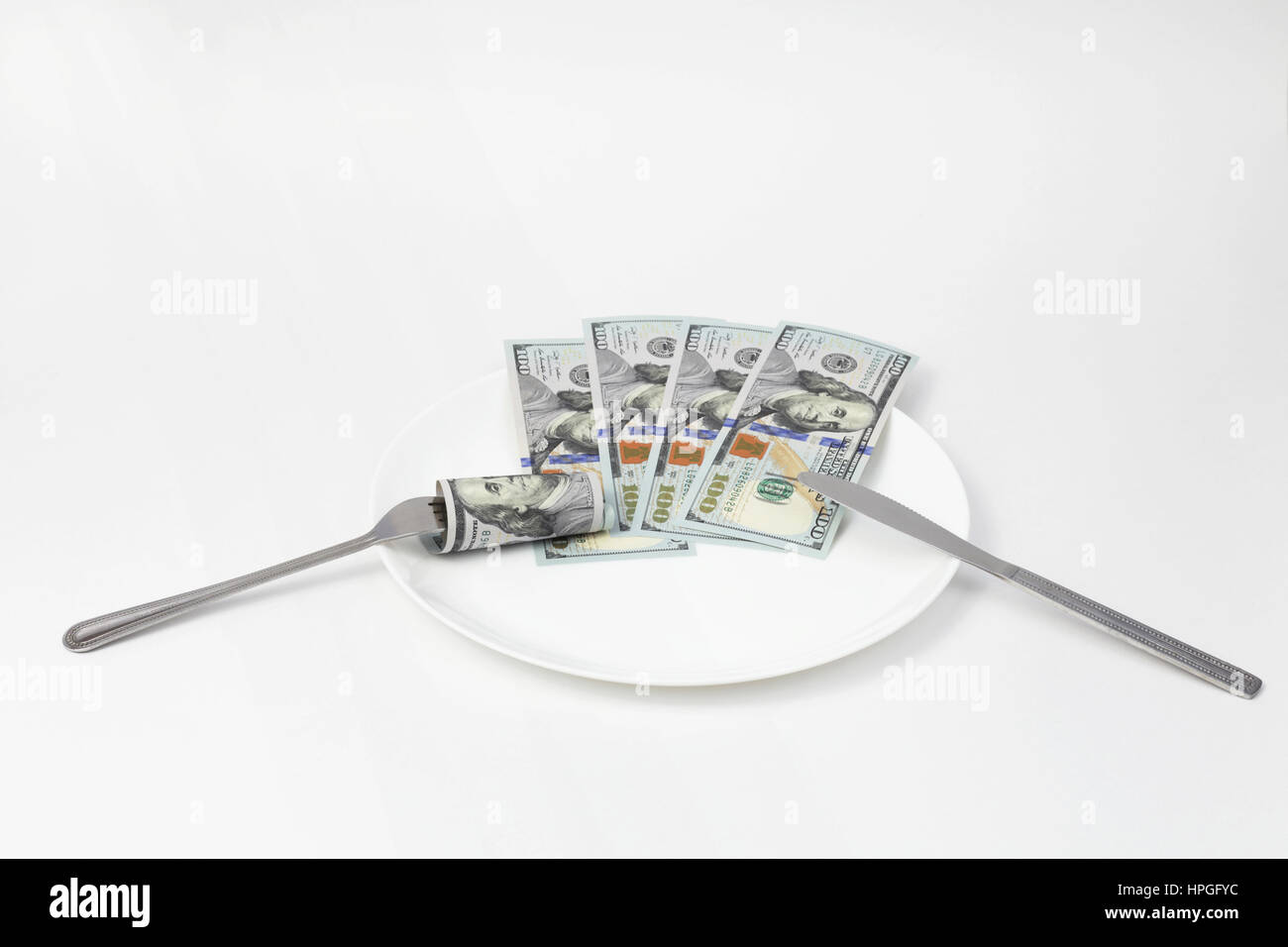 Isolato di cento dollari fatture su una piastra pranzo di lavoro Foto Stock