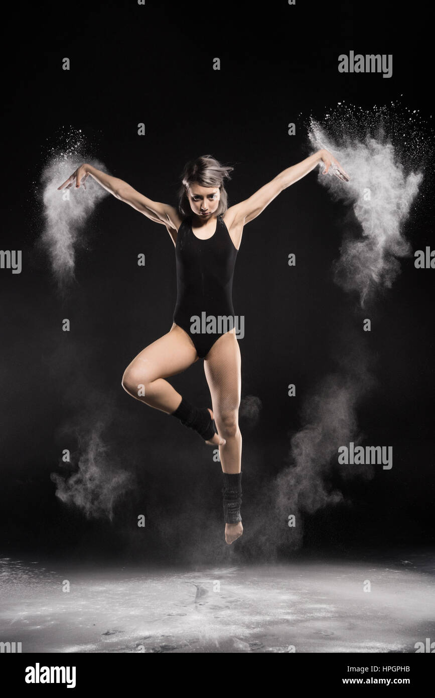 Donna concentrato in coppe con polvere jumping Foto Stock