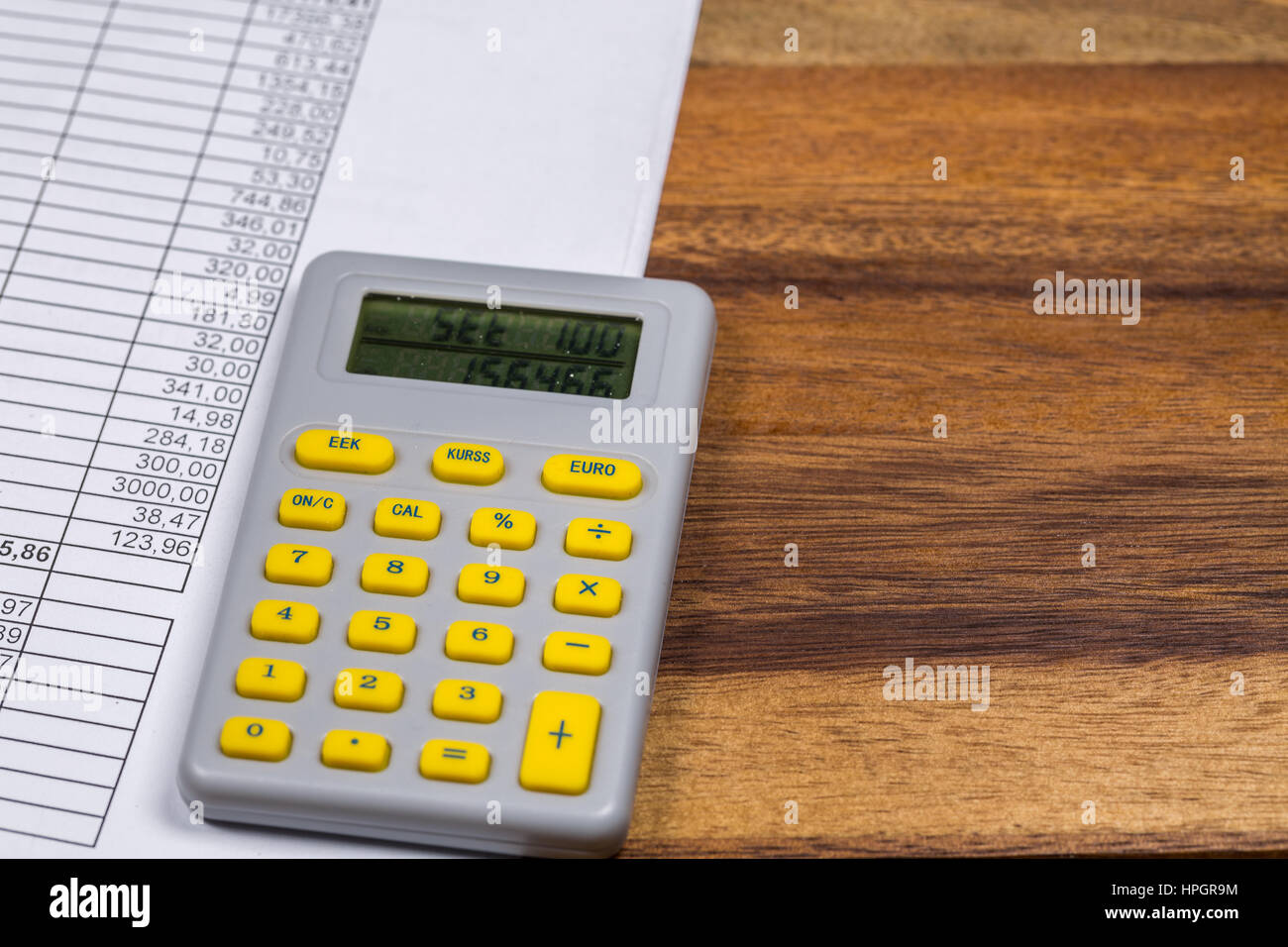 Documenti finanziari e Calcolatrice sulla scrivania in legno Foto Stock