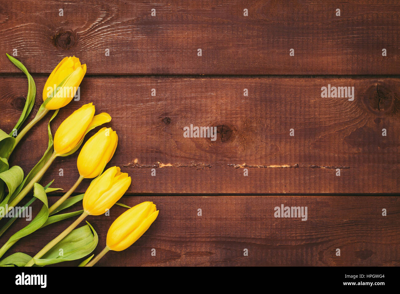 Floral background: tulipani gialli su uno sfondo di legno con copia spazio. La festa della mamma, womens giorno, concetto di Pasqua Foto Stock