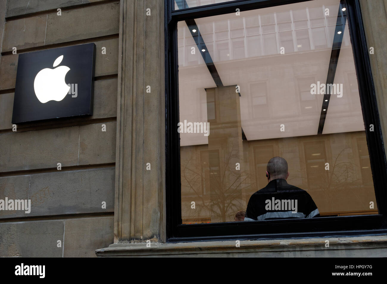 Apple store di Glasgow concetto esterno shot mirroring morso del logo con la guardia di sicurezza capo Foto Stock