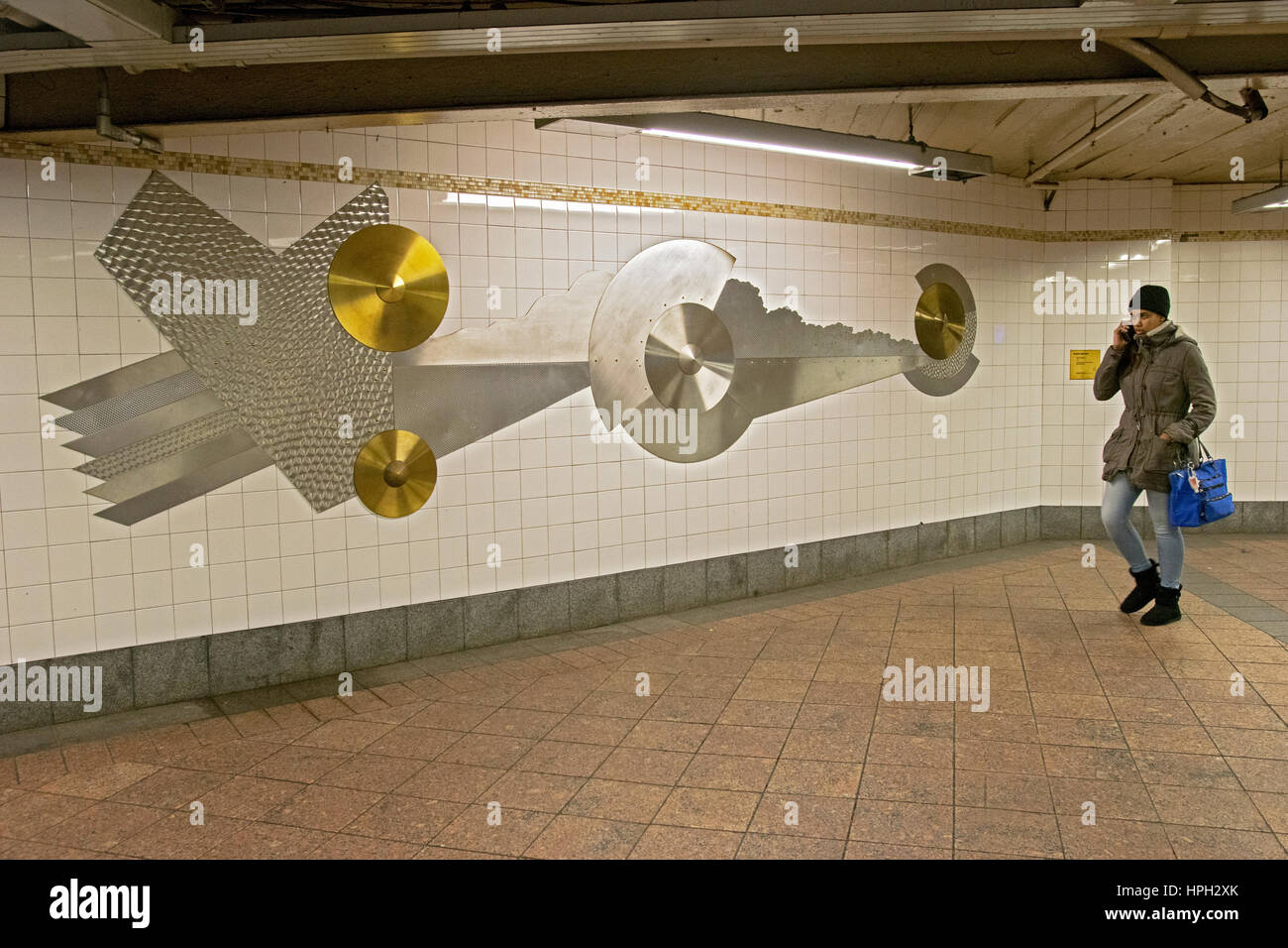 Un " commuter " su un telefono cellulare a piedi bye un pezzo di arte underground in un passaggio alla Grand Central Station nel centro cittadino di Manhattan, New York City. Foto Stock